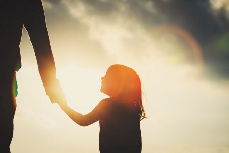 silhouette of little girl holding father's hand child support