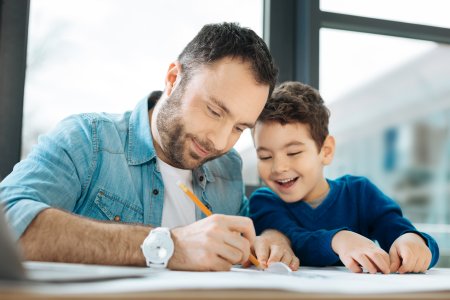 little boy watching his father sign adoption papers